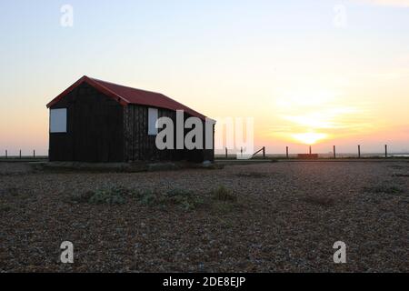 Rye Harbor, East Sussex, UK - 28.11.2020: Capanna di pesca con tetto rosso chiamata Lime Kiln Nortons cottage a Rye Harbor Nature Reserve, East Sussex UK Foto Stock