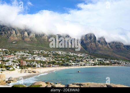 Glen Beach e Camps Bay Beach a Città del Capo, Sud Africa con dodici Apostoli coperti da nuvole dietro. Spiaggia in Sud Africa. Foto Stock