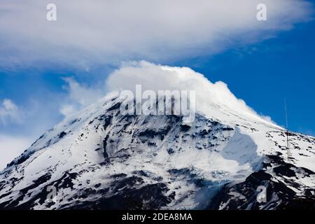 Cima del vulcano Lanin dal lago Tromen a Neuquen, Argentina. Questo vulcano è coperto da neve eterna e con alcune nuvole che si muovono che circondano il Foto Stock