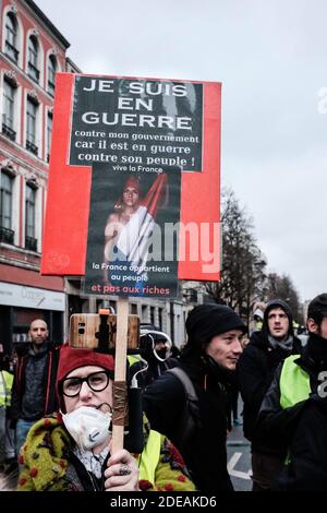 Placard 'JE suis en colère contre mon gouvernement, car il est en guerre contre son peuple!' (Sono arrabbiato con il mio governo perché è in guerra con il suo popolo!). I giubbotti gialli, per il loro sedicesimo incontro a Lille (Francia), avevano preso un appuntamento con i manifestanti dei paesi vicini. Quasi 2,000 persone hanno marciato per le strade della prefettura di Hauts-de-France, prima che si verificasse uno scontro con la polizia (proiettili lanciano contro gas lacrimogeni e arresti). Foto di Patrick BATARD / ABACAPRESS.com Foto Stock