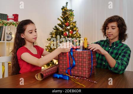Fratelli che decorano il regalo di Natale Foto Stock