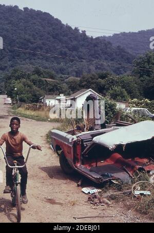 1970 Foto (1973) - Rand WV; con la maggior parte della sua popolazione che vive in povertà; ha molte strade non asfaltate e case sottostare e automobili sommerse Foto Stock