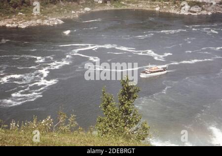 1970 Foto (1973) - la barca turistica Maid-of-the-Mist alimentata a diesel velica il fiume Niagara appena sotto le cascate. Il modello di schiuma indica l'inquinamento da acque reflue e altri rifiuti Foto Stock