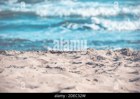 Concetto estivo e di vacanza con spiaggia. Sabbia e mare ondulato. Sfondo del viaggio. Foto Stock