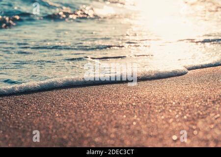 Primo piano vista delle onde marine al tramonto. Vacanza e sfondo estivo. Foto Stock