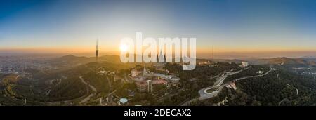 Vista panoramica del drone aereo della Basilica del Sacro cuore in cima Di Tibidabo vicino Barcellona durante il tramonto Foto Stock