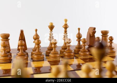 una scacchiera fatta di pezzi di legno su bianco Foto Stock