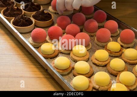 Puffs. Palle di mousse al gusto di fragola e limone su una base di biscotto Foto Stock