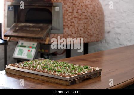 Preparazione e cottura di una focaccia pizza con purea di pomodoro e. formaggio Foto Stock