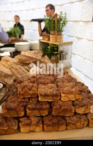 Un assortimento di panini appena sfornati e focacce di pane su un tavolo a buffet per il brunch Foto Stock