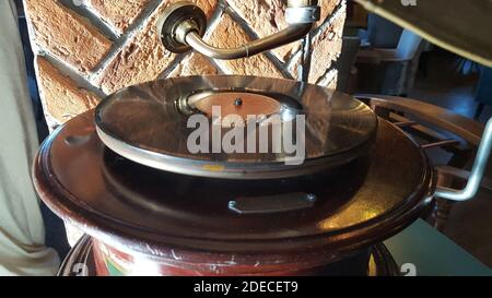 Vecchio gramofono con piastra o disco in vinile. Lettore di dischi in ottone antico. Gramophone con altoparlante a tromba. Foto Stock