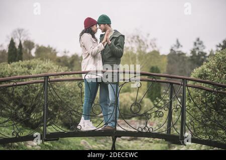 Bella coppia baciando romanticamente sul ponte Foto Stock