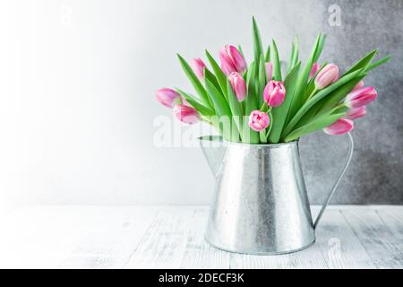Primavera sfondo floreale. Bouquet di fiori di tulipano rosa su ripiano davanti alla parete di pietra. Spazio di copia - immagine Foto Stock