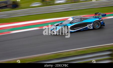 Una panoramica di una vettura da corsa mentre si guida su una pista. Foto Stock