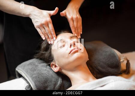 Giovane donna che riceve un massaggio facciale, rilassante al salone Spa Foto Stock