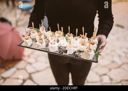 Primo piano su piatto di tenuta del cameriere con antipasti Foto Stock