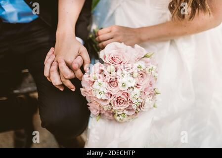 Matrimonio giovane sposa e lo sposo tenendo le mani Foto Stock