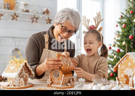 Buon Natale e buone feste. Cucina per vacanze per la preparazione della famiglia. Nonna e nipote cucina pan di zenzero casa. Foto Stock