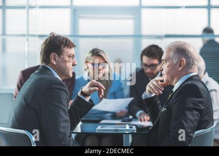 le persone che lavorano seriamente discutono dei problemi durante una riunione di lavoro Foto Stock