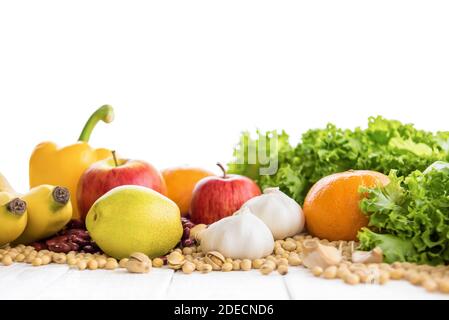 Vari tipi di frutta sana colorata, verdure, noci e spezie su tavola di legno bianco Foto Stock