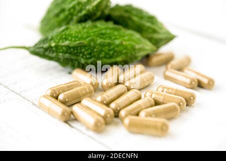 Primo piano di cetriolo o zucca amaro asiatico naturale biologico medicina vegetale a base di erbe in forma di capsule Foto Stock