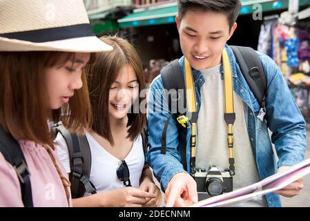 Gruppo di giovani amici turisti asiatici zaino in spalla in cerca di indicazioni per la mappa durante il viaggio in Khao San Road, Bangkok, Thailandia Foto Stock