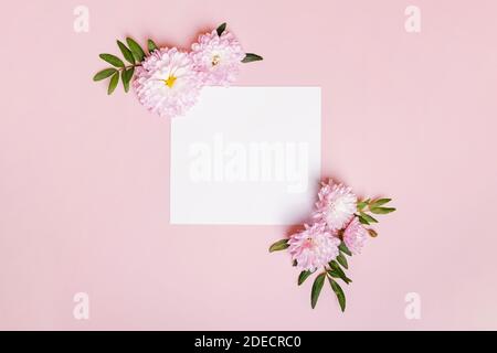 Composizione floreale creativa con carta bianca al centro. Foto Stock