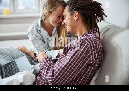 Felice giovane coppia che tocca le fronte a casa Foto Stock