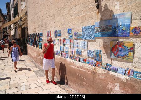 SPALATO, CROAZIA - 20 LUGLIO 2019: Turisti a piedi dal negozio d'arte locale a Spalato. La Croazia ha avuto 18.4 milioni di visitatori nel 2018. Foto Stock