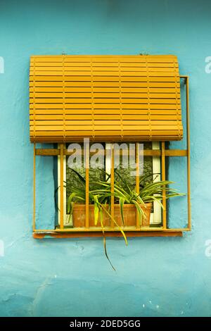 Finestra gialla sulla parete blu Foto Stock