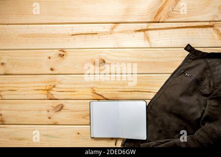 Giacca e notebook pronti a viaggiare su sfondo di legno con spazio per il testo Foto Stock