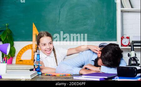 Stanco padre e figlia studiare in aula. l educazione e la conoscenza. biologia chimica lezione. uomo barbuto insegnante con piccola ragazza in aula. torna a scuola. math geometria. geometria di apprendimento. Foto Stock