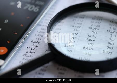 Nella tabella sono riportati i documenti con il bilancio sopra lente di ingrandimento Foto Stock