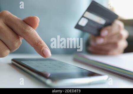 Donna effettua pagamenti online tramite smartphone closeup Foto Stock