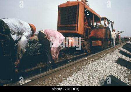 Southern Railway equipaggio di lavoro a destra con macchinari utilizzati per sostituire il vecchio binario con nuovi tratti di binari lunghi un quarto di miglio. CA. 1974 Foto Stock