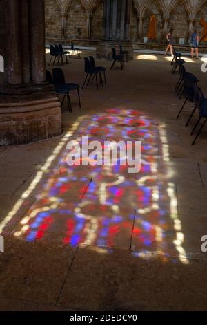 Finestra di vetro colorato con motivo illuminato sul pavimento in pietra all'interno della Cattedrale di Lincoln, Lincoln, Lincolnshire, Regno Unito. Foto Stock