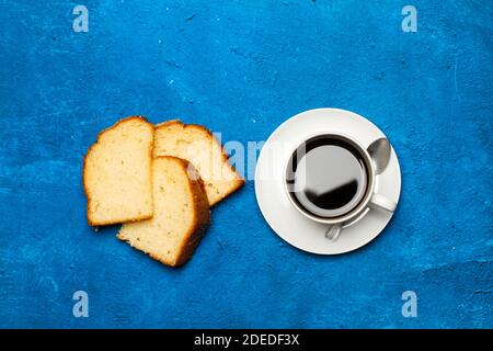 Pezzi di torta alla vaniglia e una tazza di caffè uno sfondo blu classico in una vista dall'alto Foto Stock