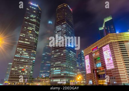 Vista notturna dei grattacieli nel nuovo quartiere di Pudong a Shanghai in un giorno nuvoloso dopo aver piovoso con luce dorata a Shanghai, Cina Foto Stock