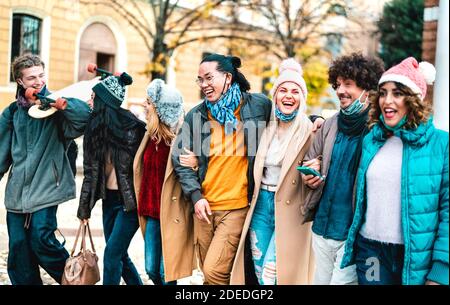 Le persone di Milenial camminano e si divertono insieme indossando il viso aperto Maschera alla città vecchia - nuovo concetto di stile di vita normale con amici multiculturali Foto Stock