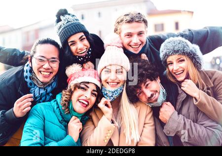 Amici multirazziali che prendono selfie con maschera aperta e inverno Vestiti - nuovo concetto di amicizia normale con la gente milenial che ha divertimento insieme Foto Stock