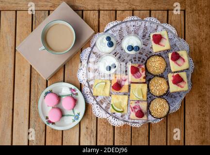 Vista dall'alto della selezione di dolci colorati e deliziosi sul vassoio sul tavolo. Foto Stock