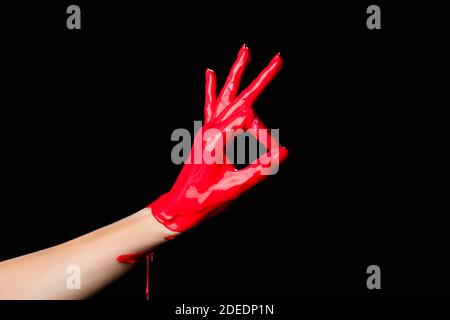 vista ritagliata di vernice rossa dipinta a mano che mostra ok segno isolato su nero Foto Stock