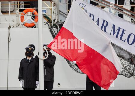 Studenti di marinai che elevano la bandiera della Polonia a Gdynia, Polonia settentrionale Foto Stock