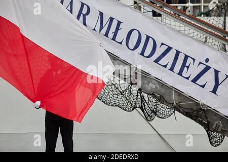 Studenti di marinai che elevano la bandiera della Polonia a Gdynia, Polonia settentrionale Foto Stock