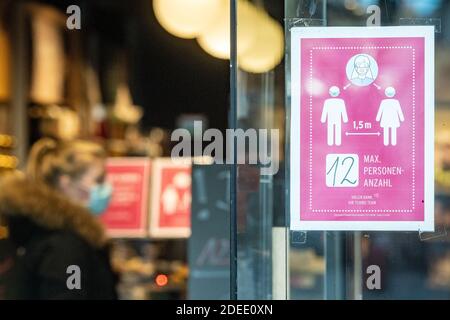 30 novembre 2020, Baviera, Passau: Un cartello con l'iscrizione "numero massimo di persone 12" è apposta ad un negozio. Secondo i dati dell'Istituto Robert Koch (RKI), la città bassa bavarese di Passau, insieme al distretto Turingio di Hildburghausen, è il punto di riferimento più importante della corona in Germania. Foto: Armin Weigel/dpa Foto Stock