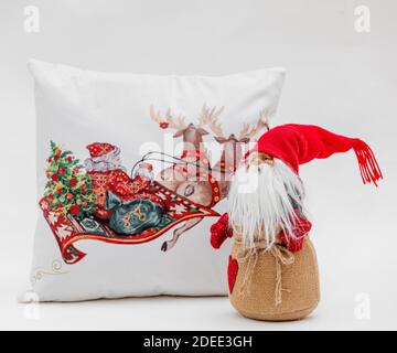 Un primo piano di un cuscino di Natale e Babbo Natale giocattolo su sfondo bianco Foto Stock