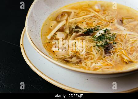 brodo di pollo con noodle su fondo nero testurizzato Foto Stock