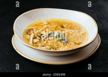 brodo di pollo con noodle su fondo nero testurizzato Foto Stock
