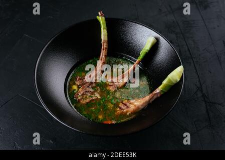 zuppa di carne con un rack di agnello su un nero sfondo Foto Stock