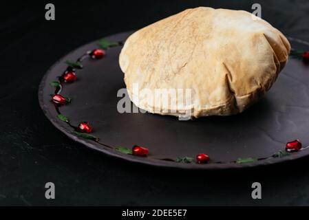 Insalata di verdure georgiane in pane di tortilla su sfondo nero Foto Stock